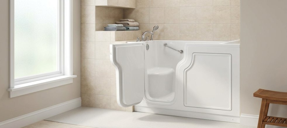 Walk-in bathtub with open door in a bright bathroom with grab bar and shower shelf